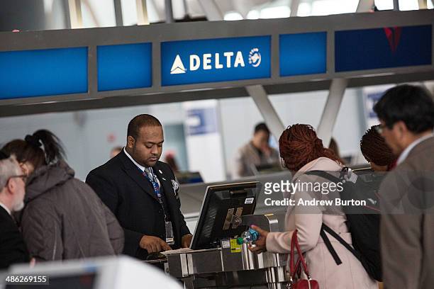 Customers check in at Delta's counter at John F. Kennedy Airport on April 23, 2014 in the Queens borough of New York City. Delta released...