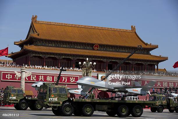 Military vehicles carrying Wing Loong, a Chinese made medium altitude long endurance unmanned aerial vehicles drive past the Tiananmen Gate during a...