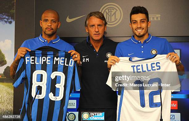 Felipe Melo and Alex Telles , new signings for FC Internazionale Milano pose with the club shirt with FC Internazionale Milano coach Roberto Mancini...