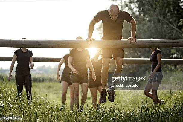 coach demonstrating to group of women how to cross obstacle - hinderbana bildbanksfoton och bilder