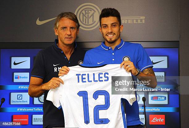 Alex Telles new signing for FC Internazionale Milano pose with the club shirt with FC Internazionale Milano coach Roberto Mancini during a press...