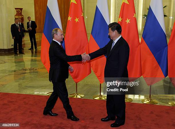 Chinese President Xi Jinping , shakes hands with Russian President Vladimir Putin before their meeting at the Great Hall of the People on September...