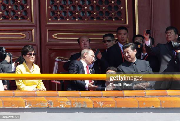Russian President Vladimir Putin chats with China's President Xi Jinping next to South Korean President Park Geun-hye on Tiananmen Gate during the...