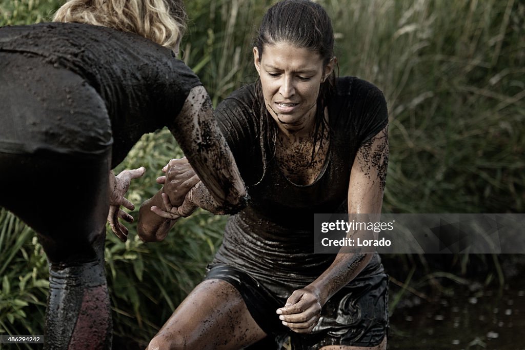 Women crossing mud obstacle