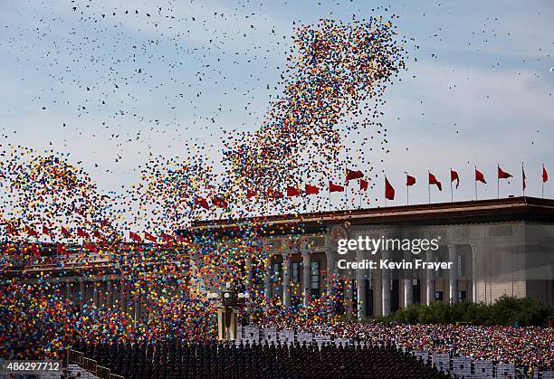 Backdropped by the Great Hall of the People balloons are released over the crowd at the end of a military parade at Tiananmen Square on September 3,...