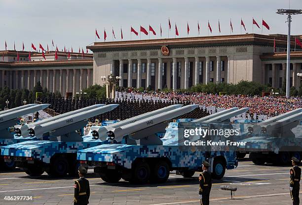 Chinese missiles are seen on trucks as they drive next to Tiananmen Square and the Great Hall of the People during a military parade on September 3,...