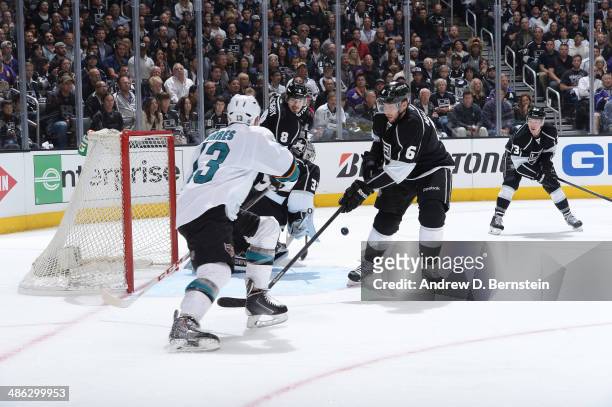 Jake Muzzin of the Los Angeles Kings takes a shot on goal against Raffi Torres of the San Jose Sharks in Game Three of the First Round of the 2014...