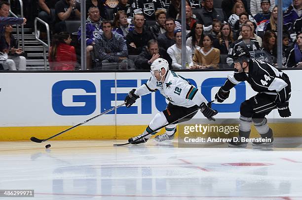 Patrick Marleau of the San Jose Sharks skates with the puck ahead of Robyn Regehr of the Los Angeles Kings in Game Three of the First Round of the...