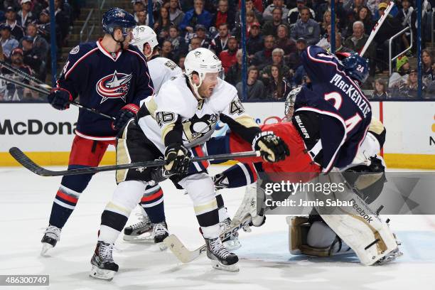 Joe Vitale of the Pittsburgh Penguins knocks Derek MacKenzie of the Columbus Blue Jackets to the ice as goaltender Marc-Andre Fleury of the...