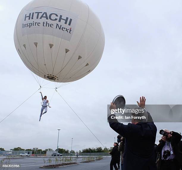 An aerial performer entertains crowds after passing over a time capsule to Mr Hiroaki Nakanishi , President of Hitachi, during the opening of the...