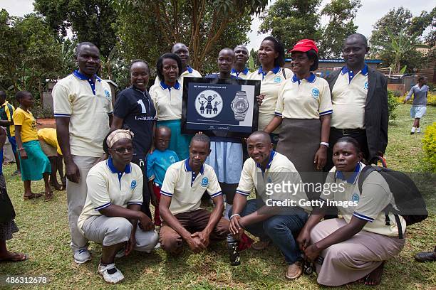 Athlete Laureus Academy Member Tegla Loroupe pose for a group photo with members of COBAP during the visit to COBAP of the IWC watch drawing...