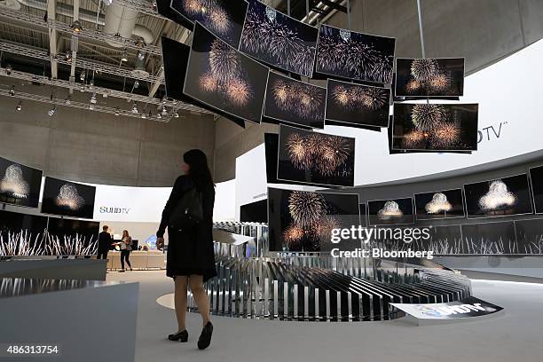 Visitor passes a display of Samsung Ultra High Definition televisions at the Samsung Electronics Co. Exhibition stand during previews for the IFA...