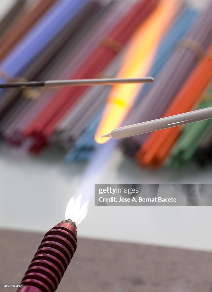Flame of a torch melting glass rods
