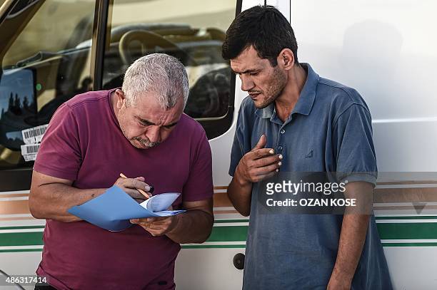 Abdullah Kurdi , father of three-year old Aylan Kurdi, talks with a man at the morgue in Mugla, southern Turkey, on September 3 after a boat carrying...