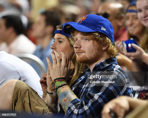 In this handout image provided by The New York Mets, Ed Sheeran watches the Philadelphia Phillies v New York Mets match at Citi Field on September 2,...