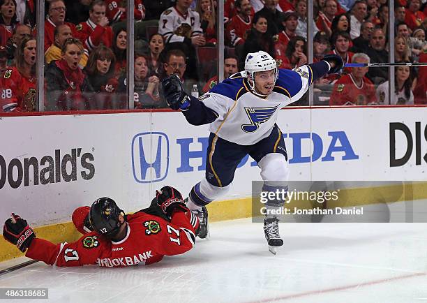 Maxim Lepierre of the St. Louis Blues knocks Sheldon Brookbank of the Chicago Blackhawks into the boards in Game Four of the First Round of the 2014...