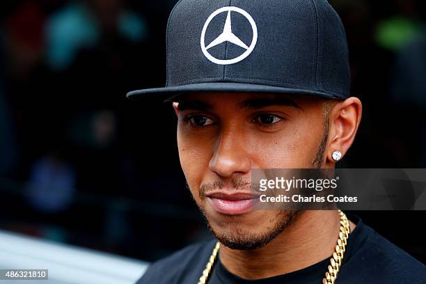 Lewis Hamilton of Great Britain and Mercedes GP speaks with members of the media in the paddock during previews to the Formula One Grand Prix of...
