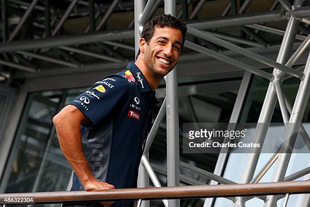 Daniel Ricciardo of Australia and Infiniti Red Bull Racing smiles as he poses for a photographer in the team hospitality during previews to the...