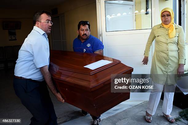 Men carry load a funeral vehicle the coffins of migrants and three-year old Aylan Kurdi, a Syrian boy whose body was washed up on a Turkish beach...