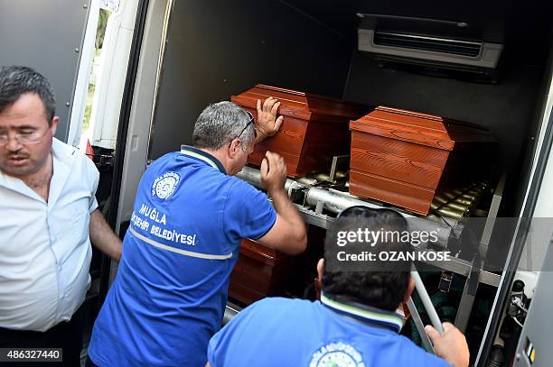 Men load onto a funeral vehicle the coffins of migrants and three-year old Aylan Kurdi, a Syrian boy whose body was washed up on a Turkish beach...