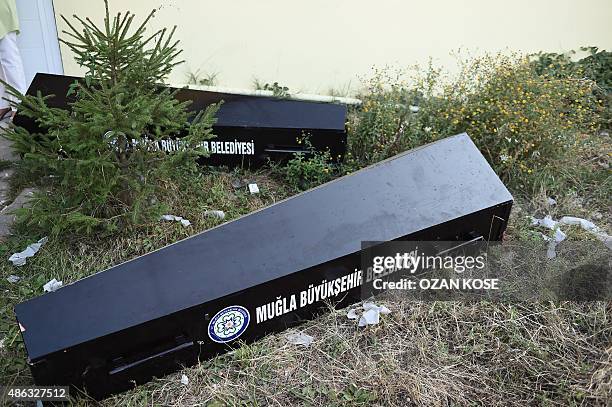 Empty coffins lie on the ground beside the entrance of the morgue in Mugla, southern Turkey, on September 3 where were taken the bodies of migrants...