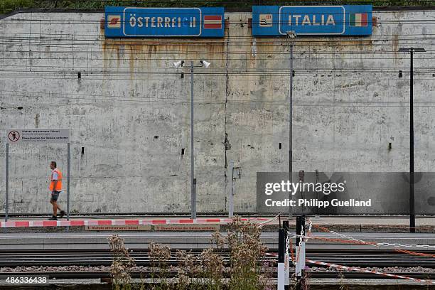 Railway worker walks past border signs next to railway tracks at the Brenner Pass on September 3, 2015 in Brennero, Italy. Italian police have...