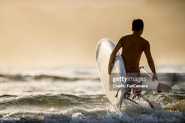 man going into the surf - fat guy on beach stockfoto's en -beelden