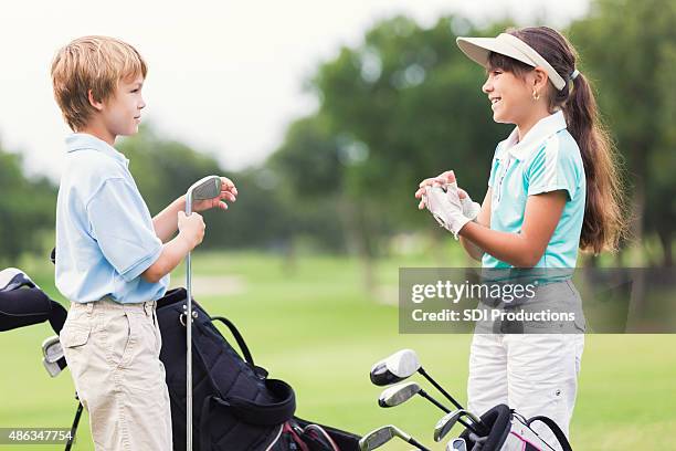 boy and girl taking golf lessons on green course - young golfer stock pictures, royalty-free photos & images