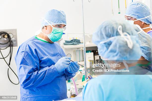 surgeon teaching medical students in hospital operating room - now showing stock pictures, royalty-free photos & images