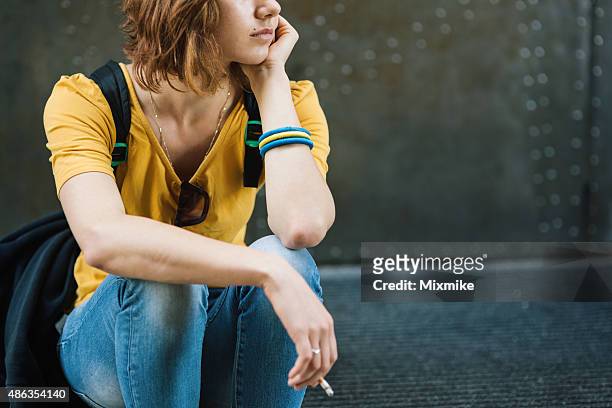 depressed teen girl smoking on stairs - smoking issues stock pictures, royalty-free photos & images