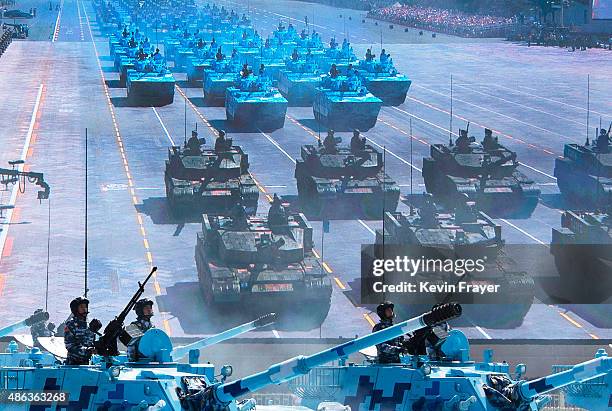 Chinese soldiers ride in tanks as they pass by a large screen at Tiananmen Square during a military parade on September 3, 2015 in Beijing, China....