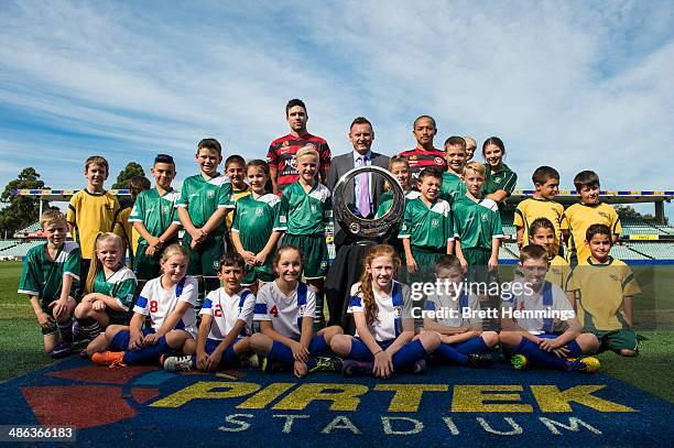 Shinji Ono, Damien de Bohun and Michael Beauchamp of the Western Sydney Wanderers pose with young football fans and the A-League Championship Trophy...