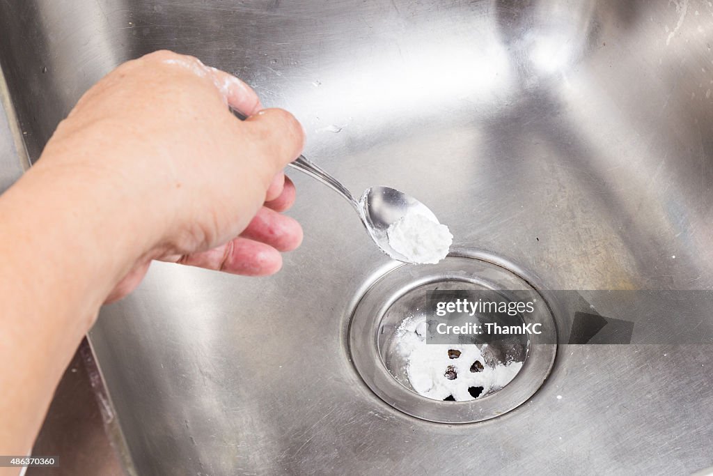 Baking soda poured to unclog drainage system at home.