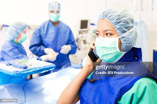 op-techniker oder krankenschwester mit anruf in operationssaal - op-mundschutz stock-fotos und bilder