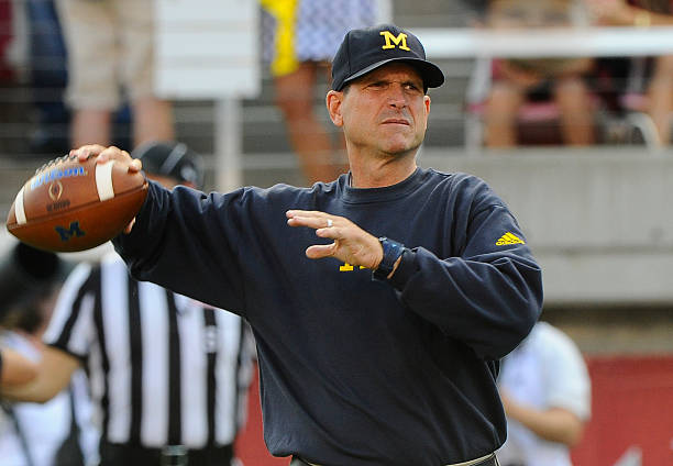 Head coach Jim Harbaugh of the Michigan Wolverines warms up his quarterbacks before their game against the Utah Utes at Rice-Eccles Stadium on...