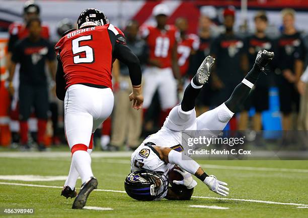Asa Jackson of the Baltimore Ravens trips and flips over as he returns a punt against Matt Bosher of the Atlanta Falcons at Georgia Dome on September...