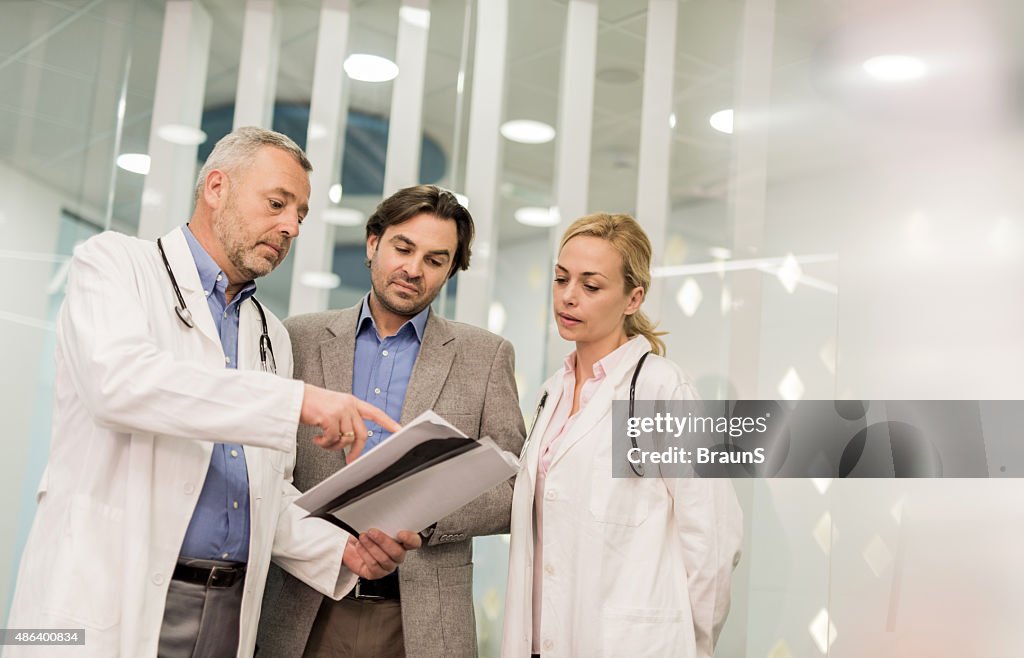 Doctors cooperating with a businessman while working on paperwork.