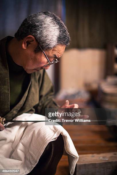 a craftsmen sharpens a traditional japanese sword - 職人 ストックフォトと画像