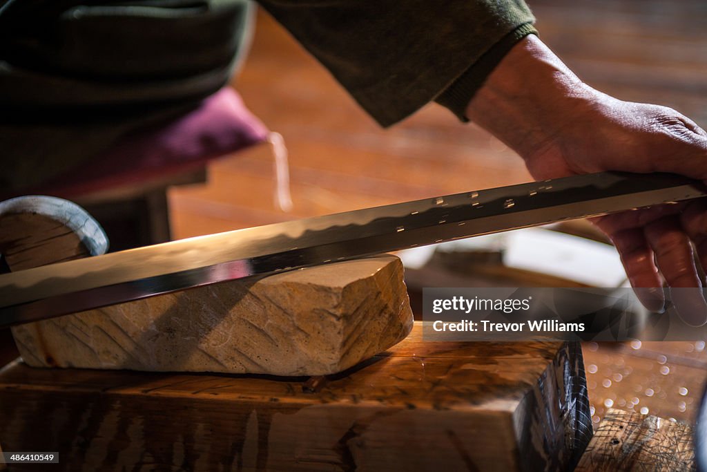 A craftsmen sharpens a traditional Japanese sword