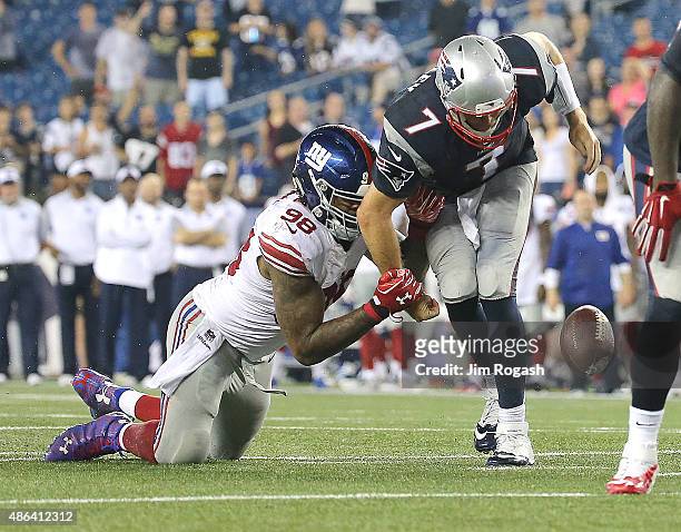 Damontre Moore of the New York Giants strips the ball from Ryan Lindley of the New England Patriots in the fourth quarter in a pre-season game at...