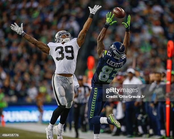 Wide receiver Ricardo Lockette of the Seattle Seahawks just misses making a catch against cornerback Keith McGill of the Oakland Raiders at...