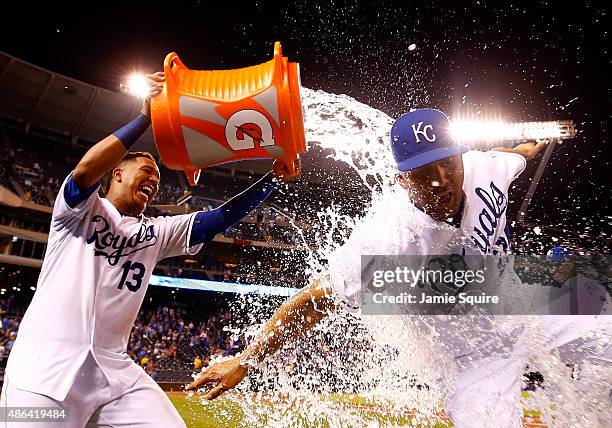Salvador Perez of the Kansas City Royals douses Kendrys Morales with a bucket of water after the Royals defeated the Detroit Tigers 15-7 to win the...