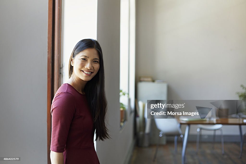 Portrait of business woman sitting in windowsill