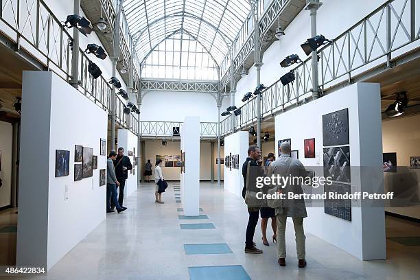 Artist of the Exhibition Tomas Van Houtryve, Guest and Writer Ryan Gattis pose in front of Thomas' works during the 'World Press Photo 2015'...