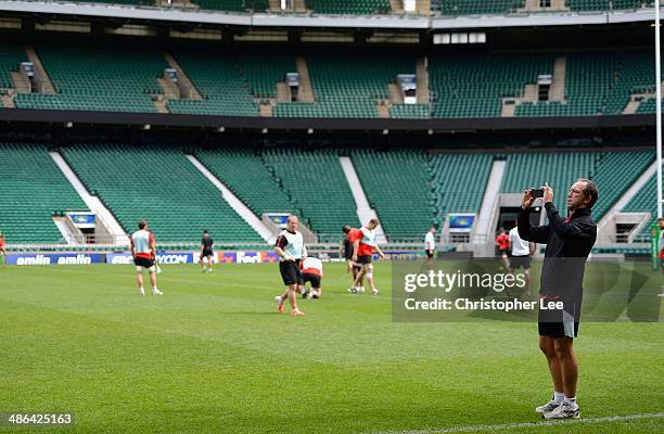 Technical Director Brendan Venter seems to be taking photographs of the stadium during Saracens Captain's Run at Twickenham Stadium on April 24, 2014...