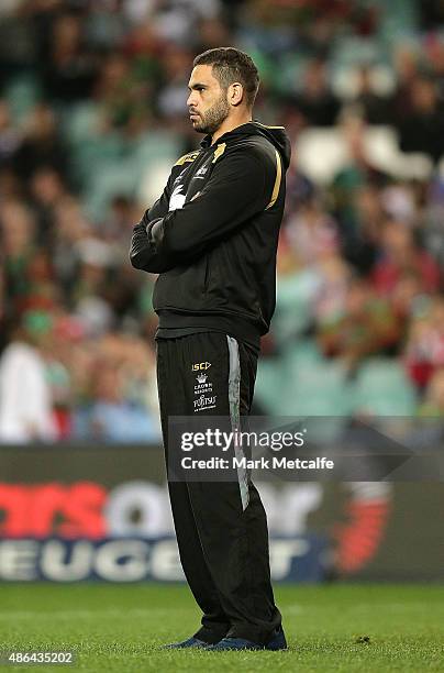 The injured Greg Inglis watches Rabbitohs team mates warm up prior to the round 26 NRL match between the Sydney Roosters and the South Sydney...