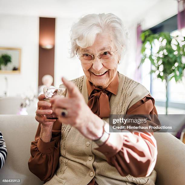 senior woman at sofa having fun - auf sich zeigen stock-fotos und bilder