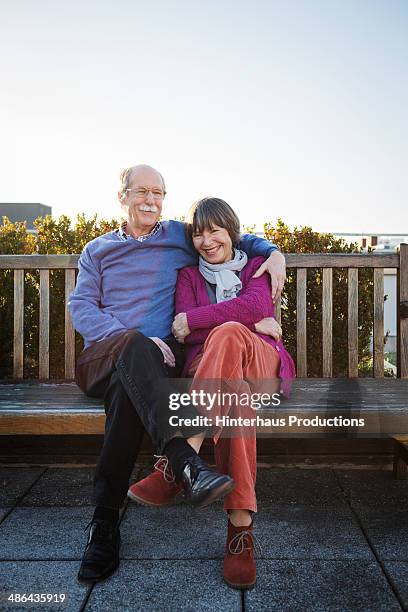 senior couple sitting at roofgarden - arm around someone stock pictures, royalty-free photos & images