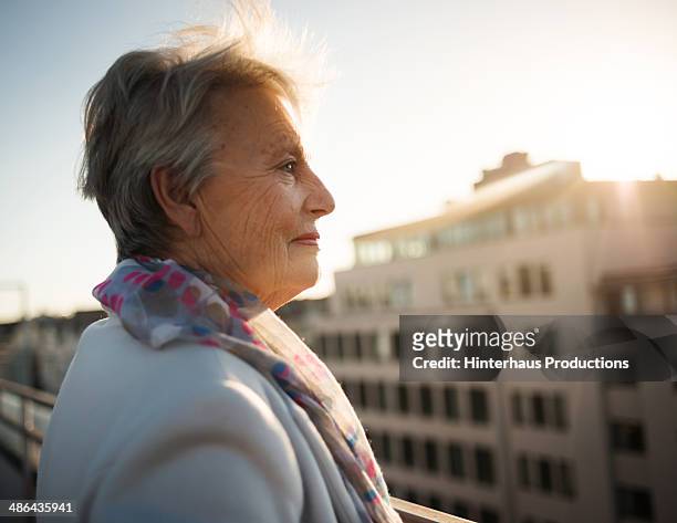 senior woman on roofgarden - seitenansicht stock-fotos und bilder