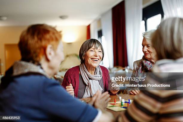 senior women playing board game - spieleabend stock-fotos und bilder